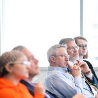 Faculty and staff members listen intently as a speaker presents.